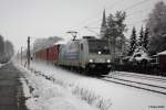 185-675 von Railpool durchfhrt im Schneegestber die Ortschaft Chemnitz Grna mit einem Container Ganzzug.