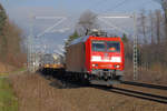 Die in frischem Rot glänzende Lok 185 052 ist bei Kilometer 61,6 der Strecke München - Rosenheim Richtung Freilassing unterwegs.