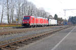 Im milden Licht eines Novembertages durchfahren 185 213 von DB Cargo und 186 288 von Railpool den Bahnhof Aßling in Richtung München mit einem langen Zug leerer Auto-Transporter.