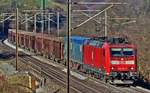 185 136-9 donnert in Hornussen mit einem Güterzug vorüber.Bild vom 6.12.2016