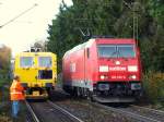 185 232-6 fährt langsam an der Stopfmaschine vorbei nach Aachen West zurück, nach dem sie einer Cobra mit einem schweren Güterzug Schubhilfe bis zum Gemmenicher Tunnel geleistet hat.
