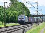 Aus der Ferne kommt die 185 534-4 mit einem Containerzug durch Thüngersheim gen Gemünden gefahren am Mittag des 24.5.2022