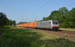Mit einer langen Leine orangener Container rollte die Railpool-Lok 186 288 am 13.06.20 durch Burgkemnitz Richtung Wittenberg.