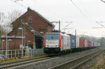 186 181 durchfährt den Bahnhof von Pulheim mit einem Containerzug.