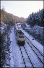 DB 103189 erreicht hier am 24.11.1990 um 10.28 Uhr im leicht verschneiten Wiehengebirge beim ehemaligen Block Tannenberg den Scheitelpunkt der Strecke. Die Lok ist mit dem IC 711 Ludwig Uhland auf der Rollbahn in Richtung Osnabrück unterwegs.