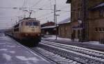 Der Himmel ist noch dunkel und hängt voll mit Schnee. Es ist der 3.3.1987 und es herrscht Chaos auf der Rollbahn. Durch Eisbruch war die Strecke nachts gesperrt. Elektrolok 103132 ist eine der ersten, die um 9.27 Uhr mit ihrem D wieder freie Fahrt in Richtung Osnabrück hat. Die Fahrleitung im Bahnhof Hasbergen ist noch stark vereist, so dass es mächtig am Stromabnehmer blitzt.