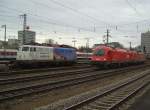 Die BR 110 325 mit Ameropa Reklame auf einem Abstellgleis und eine BR 1216 und eine 182  bei der Durchfahr am 01.12.2007 in Mnchen Ost.