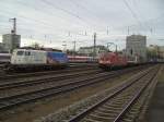 Die BR 110 325 mit Ameropa Reklame auf einem Abstellgleis und die BR 182 001 bei der Durchfahrt mit einem Containerzug am 01.12.2007 in Mnchen Ost.