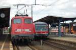 Eine Einheitslokomotive trifft auf einen Dieseltriebzug. Am 25.7.2009 trifft 110 446-2 in Aalen auf 629 340-1, welcher auf Abfahrt wartet.