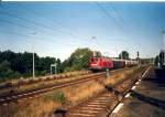 110 118 durchfhrt mit einem Sonderzug im August 2003 von Rostock kommend den kleinen Bahnhof Kratzeburg in Richtung Berlin.