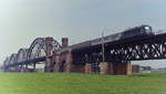 Eine Reminiszenz an die frühere Rheinbrücke zwischen Neuss und Düsseldorf: Um 1980 hat eine 110.3 mit einem Eilzug das Neusser Ufer erreicht.