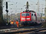 111 114 schiebt am 21.11.2011 den RE4 nach Aachen West, whrend an dem Nachbargleis unbeeindruckt an einer Weichenantriebabdeckung weitergearbeitet wird