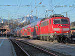 Lok 111 031-1 führt einen morgendlichen München - Salzburg Express. Im Bahnhof Traunstein verlaufen die Gleise Richtung Nordosten, deshalb werden 7.26 Uhr sowohl die Lokomotive als auch die Berge von der Sonne angestrahlt. Die Doppelstockwagen waren das Beste, was je zwischen München und Salzburg fuhr. Traunstein, 16. März 2012.