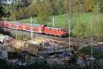 Auf der Fahrt von Lindau-Reutin nach Stuttgart schiebt 111 012 die Wagen des RE 5 / 4222 am 28.10.2022 im Schussentobel bei Kilometer 162.0 an einer Brückenbaustelle vorbei.