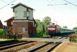 Das stillgelegte Stellwerk des ehemaligen Bahnhofs Eilvese (spter Ausweichanschlussstelle, heute Haltepunkt) und 112 148 mit IR 2585 (Wilhelmshaven Hbf–Hildesheim Hbf) am 30.06.1993