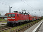 Die Elektrolokomotive 112 186 zieht eine RE-Doppelstockgarnitur in Richtung Rostock.