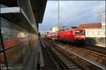 DB 114 018-5 mit dem RE5 nach Lutherstadt Wittenberge. Sie spiegelt sich in der durchsichtigen Verkleidung des Treppenaufgangs zum S-Bahnhof bei schon tiefstehender Sonne (Berlin Wedding, 05.07.2009)