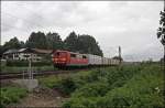 151 130 ist mit einem Holzhackschnitzelzug bei Bernau am Chiemsee unterwegs.