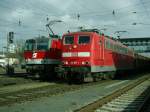 Die BB 1044 015 mit einem Autozug und die DB 151 041 mit Rohholz, beide unterwegs Richtung Salzburg, warten im Welser Hbf auf die Weiterfahrt.