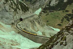 Noch etwas Schnee ist da: Stilgerechter Zug der Wendelsteinbahn bei der Hohen Mauer im Sommer 1984