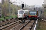 BERLIN, 13.04.2010, S9 nach Flughafen Schönefeld bei der Einfahrt in den S-Bahnhof Landsberger Allee neben einem haltenden ICE 3 in Richtung Gesundbrunnen