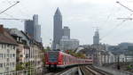 Eine S5 nach Friedrichsdorf erreicht den Bahnhof Frankfurt West über die charakteristische Rampe mit der Skyline im Hintergrund.