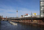 ICE 402011 ist hier am 13.3.2026 um 10.29 Uhr zwischen Jannowitzbrücke und Michaelbrücke in Richtung Berlin Ostbahnhof unterwegs. Gleichzeitig ist ein Schubschiff der Rhenus Logistics in Richtung Osten auf der Spree unterwegs.