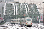 Eine 403er-Doppeltraktion im verschneiten Bahnhof Köln Messe / Deutz nebst Hohenzollernbrücke im Hintergrund.