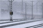 Starker Schneefall in München -     Teilweise verdeckt auch den aufwirbelnden Schnee rauscht ICE T Freie und Hansestadt Hamburg vorbei am S-Bahnhalt Hirschgarten.