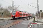 Brrrrrrrrrr, bei usseligem Schneeregen fhrt der 425 526-1 an den Bahnbergang Jakob-Krebs-Strae heran.