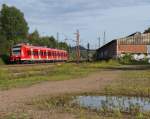 425 112 ist als RE Kaiserslautern - Trier auf der Saarstrecke unterwegs. Die Halle auf der rechten Seite gehörte mal zum Außenlager des Brückenlagers Karthaus und auch mal zu einem Schrotthändler der E 94 Loks zerlegt hat. Bahnstrecke 3230 Saarbrücken - Karthaus bei Bous Saar am 28.08.2014 