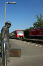 Warten auf den Zug - doch in diesen einfahrenden RB nach Lindau wird die ewig wartende Skulptur in Nonnenhorn sicher nicht einsteigen.