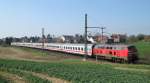 218 321-8 zieht am 10.04.09 den IC 2120 Frankfurt (M) Hbf - Puttgarden durch Reinfeld (Holst.) durch eine kleine Talsenke. Im Hintergrund sind die ersten Huser von Reinfeld (Holst.) zu erkennen.