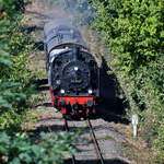 Umgeben von spätsommerlich grüner Flora bewegt sich die Dampflokomotive 38 2267 mit ihrem Sonderzug durch Hattingen.