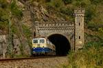 DB E10 1239 mit Rheingold bei der Durchfahrt aus dem Banktunnel am Rhein, August 2024.