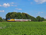Eine niederländische Vectron rauscht mit dem Umleiter IC Berlin-Amsterdam auf dem Umleitungsweg über Hannover-Altenbeken-Hamm-Münster-Rheine durch die Felder kurz hinter dem Haltepunkt Scharmede Richtung Hamm. Juli 2025