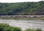 185 591-5 der Crossrail mit einem Containerzug, fhrt am 11.08.2011 auf der linken Rheinseite, gegenber von Unkel, abwrts in Richtung Kln.