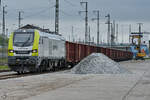 Die Captrain-Hybridlokomotive 159 102-3 wartet auf die Entladung der angehängten offenen Güterwagen.