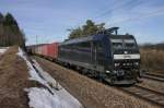 185-551 der MRCE in der warmen Mittagssonne mit einem Containerzug.(KBS 880,bei Parsberg,27.02.2010)