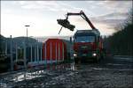 Holzumschlag mit Sonnenuntergang und den Schweizer im Sauerland: Der Fahrer des MAN TGA verldt in den Abendstunden des 07.02.2008 in Brgge (Westf) seine Ladung Stammholz auf Fabrikneue(?) Rnoos644.