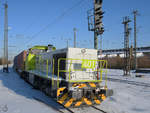 Die Diesellokomotive 401 zieht am Hauptbahnhof Wanne-Eickel einen Containerzug, so gesehen im Februar 2021.