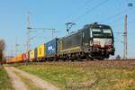 193 867 BEACON mit Containerzug in Dedensen Gümmer, April 2025.