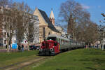 322 607-3 zieht ihren Zug mit 52 4867 am Zugschluss auf der Frankfurter Hafenbahn aus dem Haltepunkt Eiserner Steg Richtung Griesheim. Im Hintergrund ist die Kirche St. Leonhard (16.03.2025)