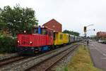 Entlang der Deichstraße bringt die Lok  Aurich  der Borkumer Kleinbahn am 30.06.2021 Urlauber vom Kleinbahnhof zur Reede