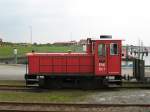 26.07.2007: K 1 der Inselbahn Langeoog wartet vor einem Gterzug im Hafenbahnhof der Insel auf die Beladung  