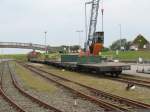 26.07.2007: K 1 der Inselbahn Langeoog wartet vor einem Gterzug im Hafenbahnhof der Insel auf die Beladung  