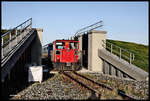 DB Schöma Lok 399108 fährt hier am 1.10.2017 mit einem Personenzug vom Hafen Wangerooge kommend durch das Deichtor in Richtung Bahnhof.