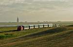An einem der längsten Tage des Jahres, dem 20.06.2018, ist 399 108-0 mit dem abendlichen Zug vom Anleger in Richtung Wangerooge Ort unterwegs. Gerade rechtzeitig rissen die Wolken auf, so dass der Zug von der langsam untergehenden Sonne angestrahlt wurde.