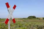 Schienenfahrzeuge haben Vorrang! Das gilt auch auf Wangerooge. Im Hintergrund verluft die Strecke in einem weiten Bogen zu den Landschulheimen im Westen der Insel.
16.07.2013.