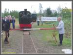 Nach den offiziellen Ansprachen anlsslich der Erffnung des neuen Streckenabschnitts des Frankfurter Feldbahnmuseums entfernten der Vorsitzende des Feldbahnmuseums und der Herr Stadtrat Brger symbolisch den Schlagbaum der Schranke und gaben damit die Fahrt frei an den neuen Endpunkt fr den im Hintergrund stehenden Zug. Die Ehre, den Erffnungszug zu fhren, gebhrte der Lok  Decauville  Baujahr 1915 deren Inbetriebnahme nach sieben Jahren der Aufarbeitung ebenfalls mit dem Feldbahnfest gefeiert wurde.